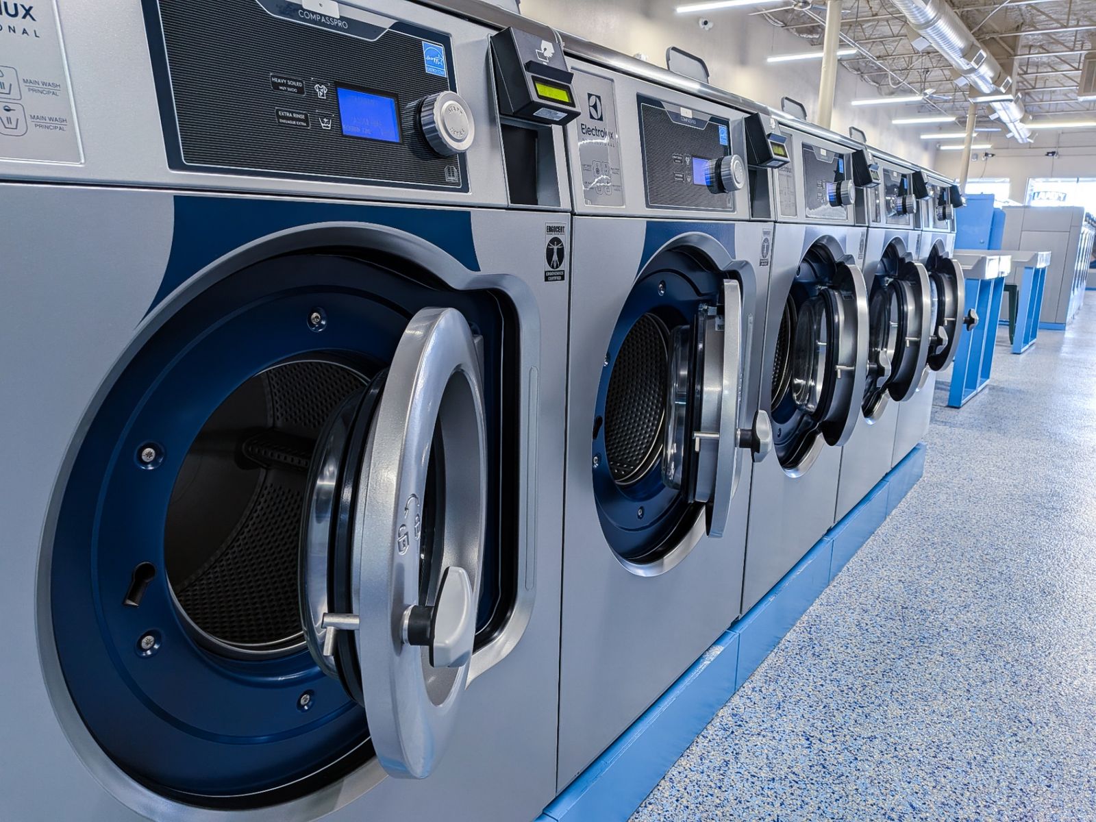 Row of brand-new Electrolux CompassPro commercial washers with doors open